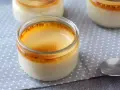 Trois pots de crème aux œufs, avec une croûte caramélisée dorée, sur une nappe à pois.