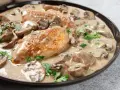 Un plat de poulet à la crème onctueuse, parsemé de champignons et de persil frais. Un délice crémeux qui invite à la dégustation.