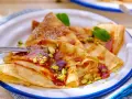 Délicieuses crêpes salées au beurre, garnies de pistaches concassées et d'un coulis rouge. Une touche de menthe apporte de la fraîcheur.