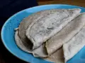Galettes de sarrasin, naturellement sans gluten, sur une assiette bleue. La farine de blé noir donne cette texture rustique.