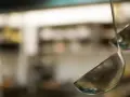 Deux louches en métal suspendues dans une cuisine. L'une est au premier plan, l'autre est floue en arrière-plan.