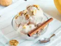 Un délicieux bol de glace au yaourt, garni de noix et d'un bâton de cannelle. Un délice rafraîchissant !