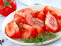 Une assiette de salade de tomates fraîches, assaisonnée de poivre noir et d'aneth. Un délice simple et coloré.