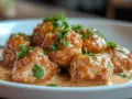 Boulettes de viande savoureuses baignant dans une sauce crémeuse, garnies de persil frais. Un plat réconfortant prêt à être dégusté.