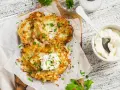 Délicieux rapé de pomme de terre doré, garni de crème fraîche et de persil, prêt à être dégusté avec une touche de paprika.