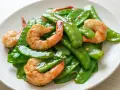 Crevettes sautées avec pois gourmand croquants, un plat coloré et savoureux.