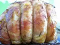 Un délicieux roti de veau, enveloppé de lard et parsemé de romarin, prêt à être dégusté.