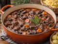 Un plat mijoté de daube de boeuf, avec des carottes, des olives et des herbes, prêt à être dégusté.
