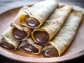 Crêpes roulées généreusement garnies de chocolat fondant. Une idée garniture crêpe sucrée irrésistible pour un goûter gourmand.