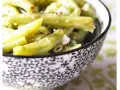 Salade de haricots verts croquants, assaisonnée et parsemée de quelques épices rouges, servie dans un bol décoratif.