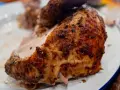 Un morceau de poulet braisé, doré et savoureux, est servi sur une assiette blanche.