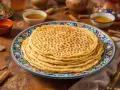 Pile de crêpes aux alvéoles parfaites, une merveille qui répond à la question : pourquoi ma pâte à crêpe fait des trous. Servies avec du miel.
