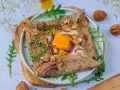 Délicieuse galette de sarrasin garnie d'un œuf, oignons rouges et noix. Parfait pour un repas pour 4 personnes.