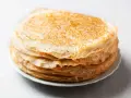 Pile de 10 crêpes sucrées dorées, prêtes à être garnies. Une recette simple pour un plaisir gourmand.