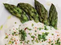 Asperges vertes tendres nappées d'une onctueuse sauce mousseline, parsemées de ciboule et de piment. Un délice printanier.