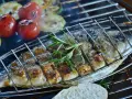 Dorade au barbecue, grillée à la perfection avec des tomates et des courgettes. Une branche de romarin parfume ce plat savoureux.