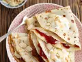 Crêpes fines garnies de confiture et de crème, parsemées d'amandes effilées. Une délicieuse recette crêpe sans beurre pour un goûter léger.