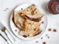 Crêpes garnies de nutella liquide pour crêpe, parsemées de noisettes concassées. Un délice gourmand !