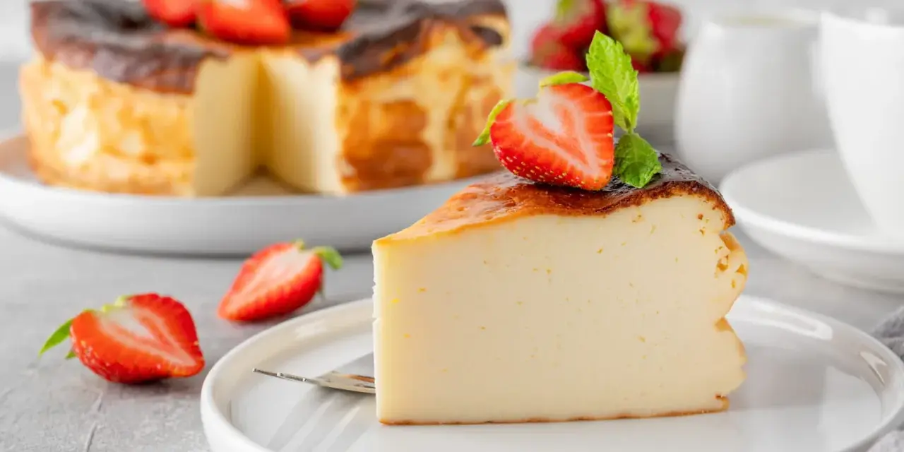 Tranche de gâteau au fromage brûlé, garnie de fraises et de menthe. Un dessert facile qui impressionne, parfait pour toute occasion.