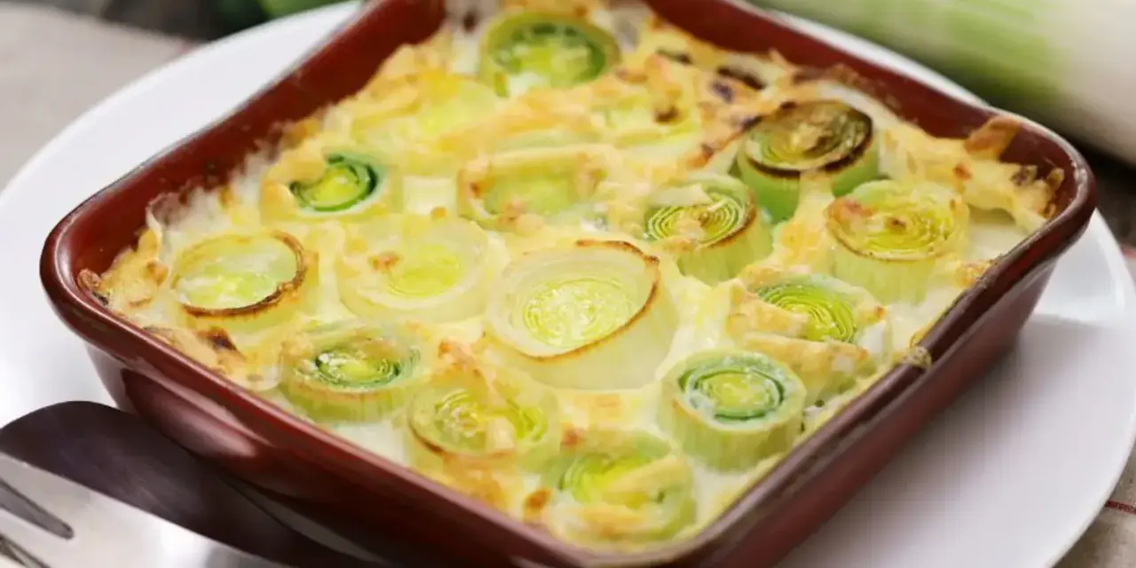 Un délicieux gratin de poireaux crémeux, prêt à être dégusté. Les poireaux coupés en rondelles sont nappés d'une sauce onctueuse et gratinés à la perfection.