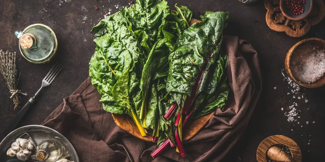 Blettes fraîches, ail, herbes et épices pour une délicieuse recette blette. Huile d'olive et sel complètent les ingrédients.