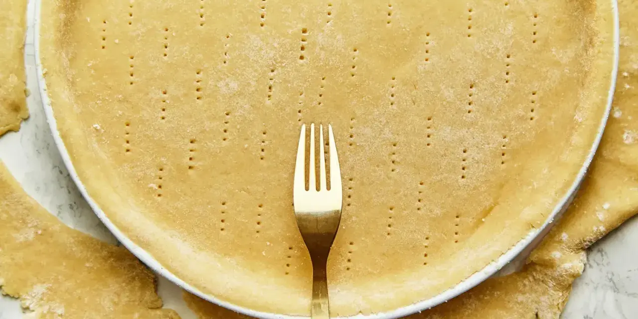 Une pâte brisée sans beurre, piquée à la fourchette, prête à être garnie.