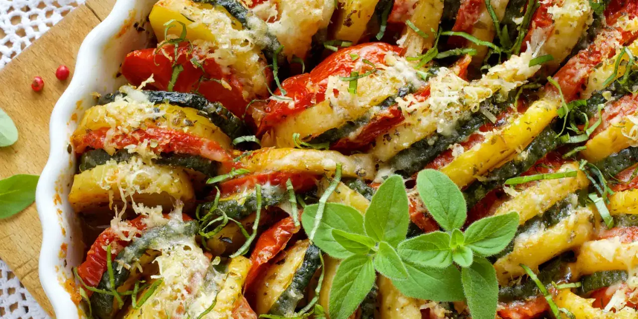 Un délicieux tian de légumes, aux rondelles de pommes de terre, courgettes et tomates, gratiné au fromage et parsemé d'herbes fraîches.
