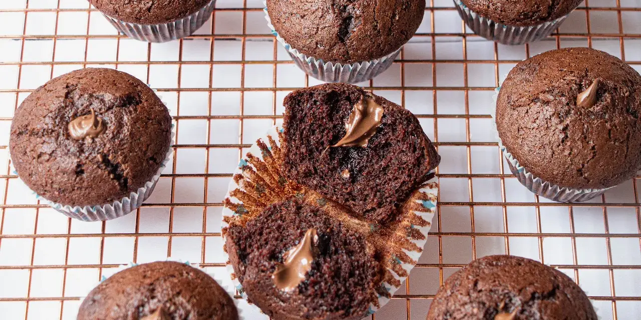 Plusieurs muffins au chocolat, dont un ouvert révélant une généreuse garniture de nutella.