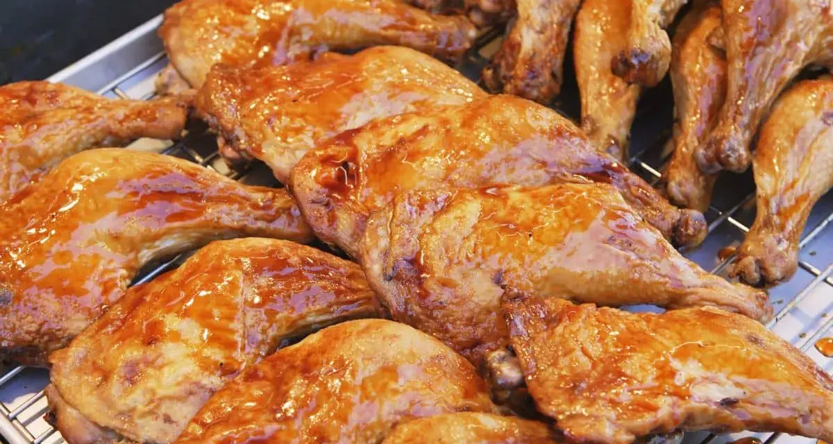 Une belle rangée de pilons de poulet rôtis, brillants d'une sauce caramélisée, prêts à être dégustés.