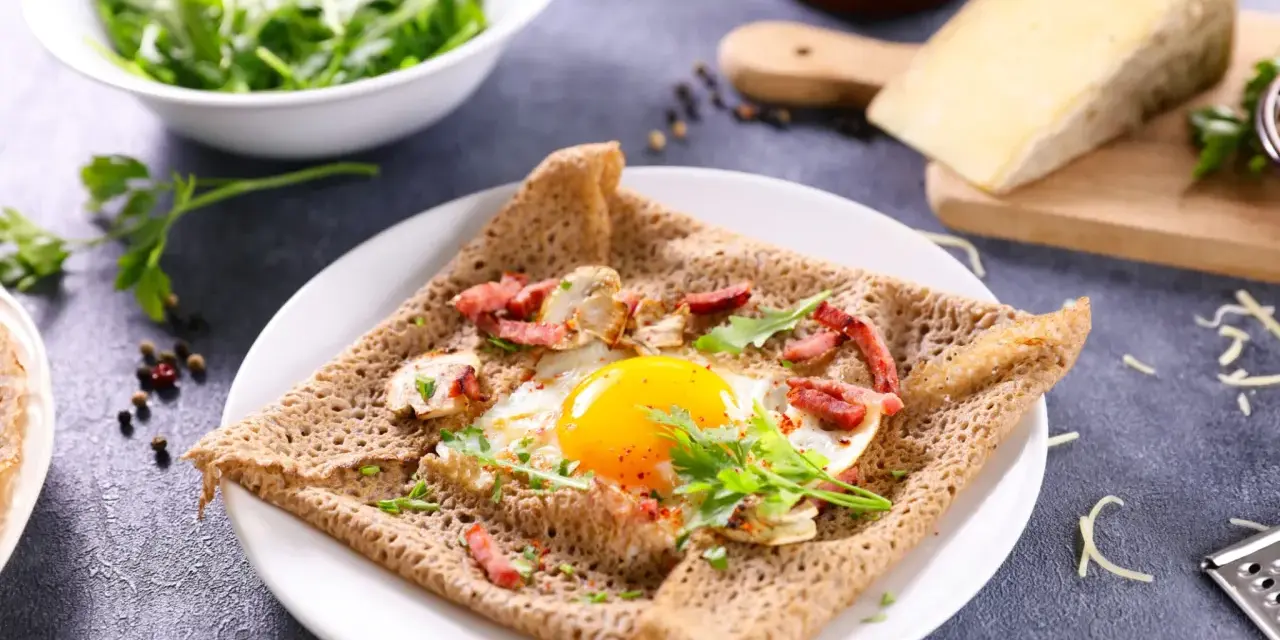 Une galette de sarrasin garnie d'un œuf au plat, de lardons et de champignons. Un délice pour un petit-déjeuner ou un brunch.