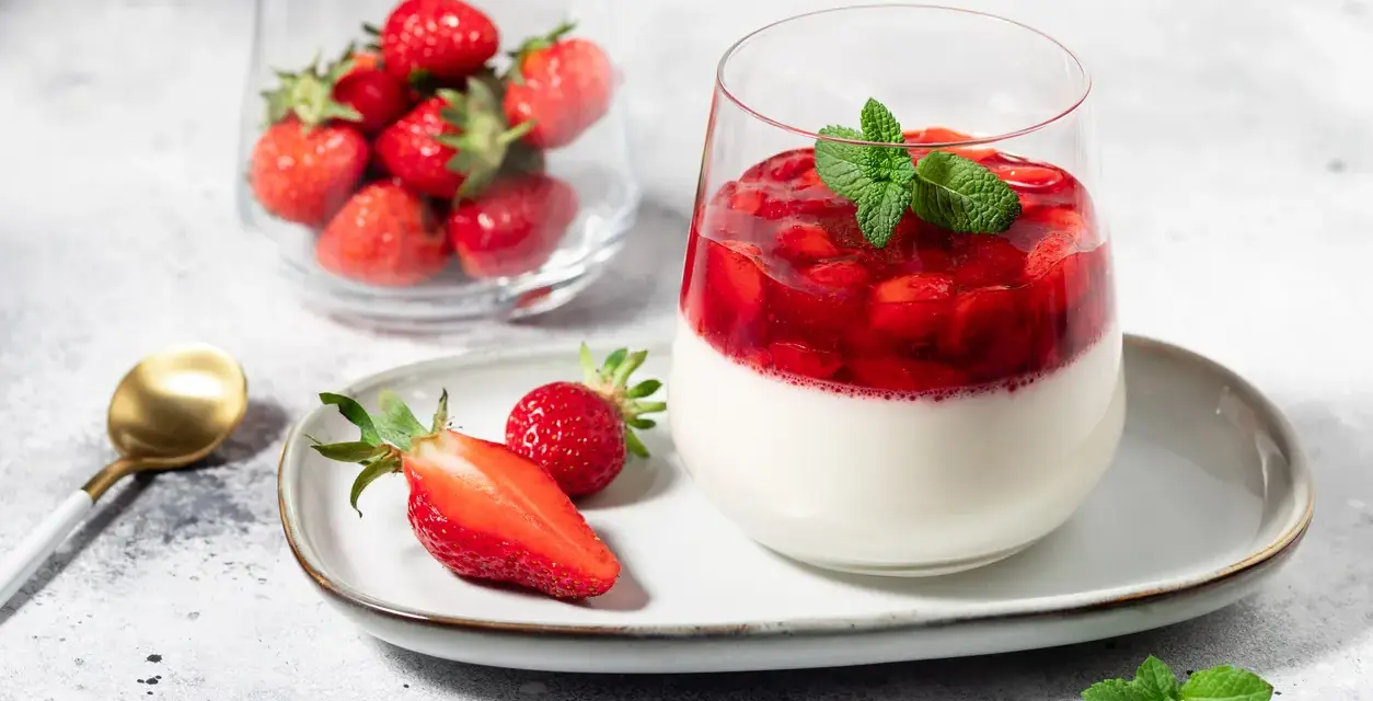 Délicieux panna cotta fraise, garni de fruits rouges frais et d'une touche de menthe. Un dessert léger et fruité.