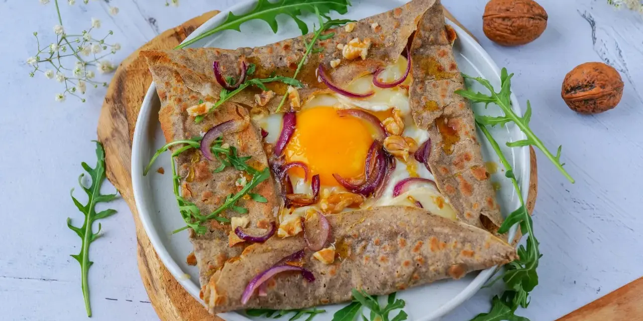 Délicieuse galette de sarrasin garnie d'un œuf, oignons rouges et noix. Parfait pour un repas pour 4 personnes.