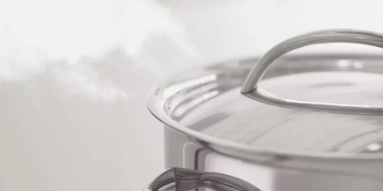 Vapeur s'échappant d'une casserole en inox. Le temps de cuisson du potimarron à l'eau approche de la fin.