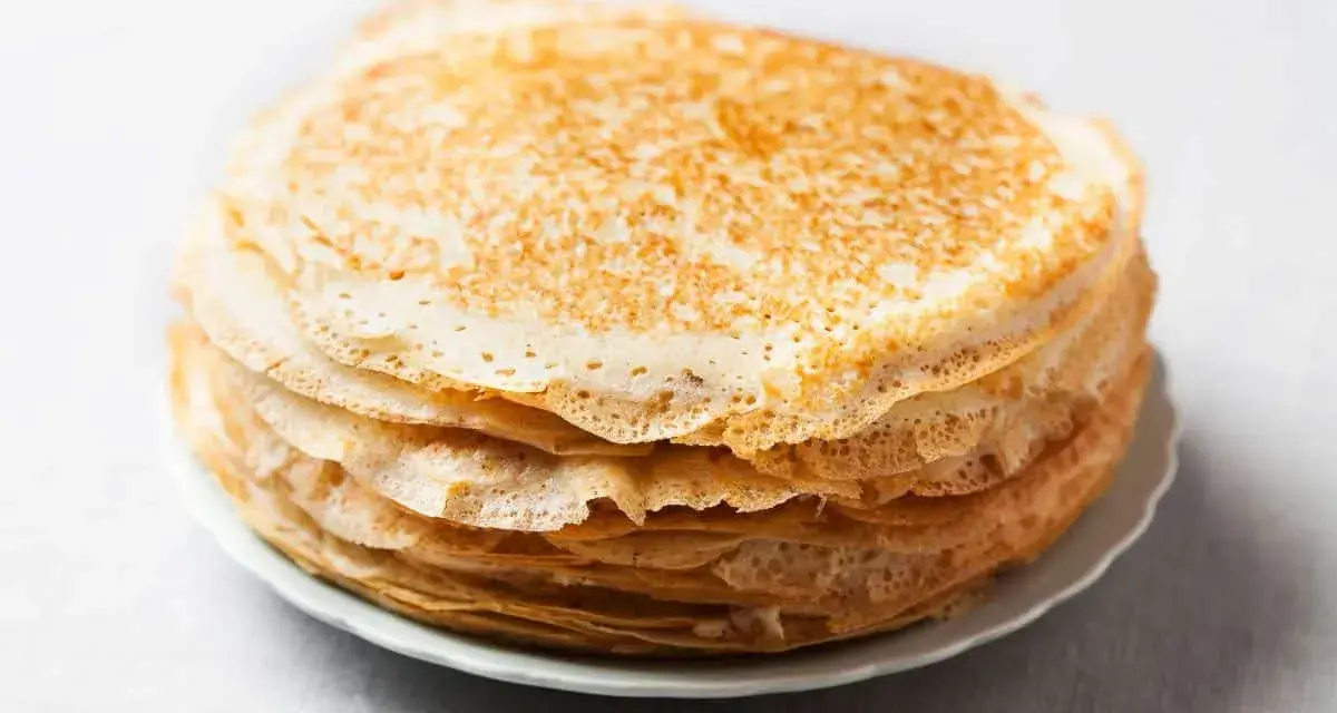 Pile de 10 crêpes sucrées dorées, prêtes à être garnies. Une recette simple pour un plaisir gourmand.