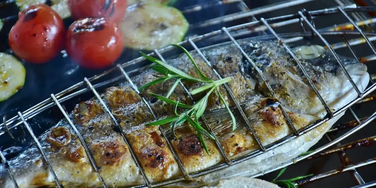 Dorade au barbecue, grillée à la perfection avec des tomates et des courgettes. Une branche de romarin parfume ce plat savoureux.