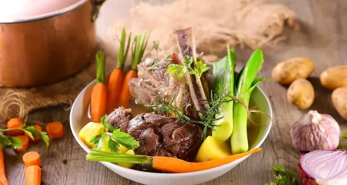 Un plat de pot-au-feu réconfortant avec du bœuf, des carottes, des poireaux et des pommes de terre, prêt à être dégusté.
