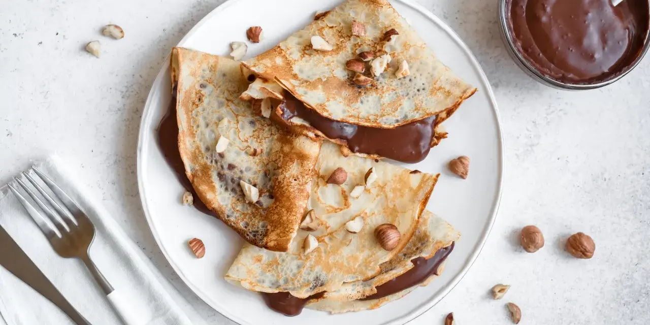 Crêpes garnies de nutella liquide pour crêpe, parsemées de noisettes concassées. Un délice gourmand !