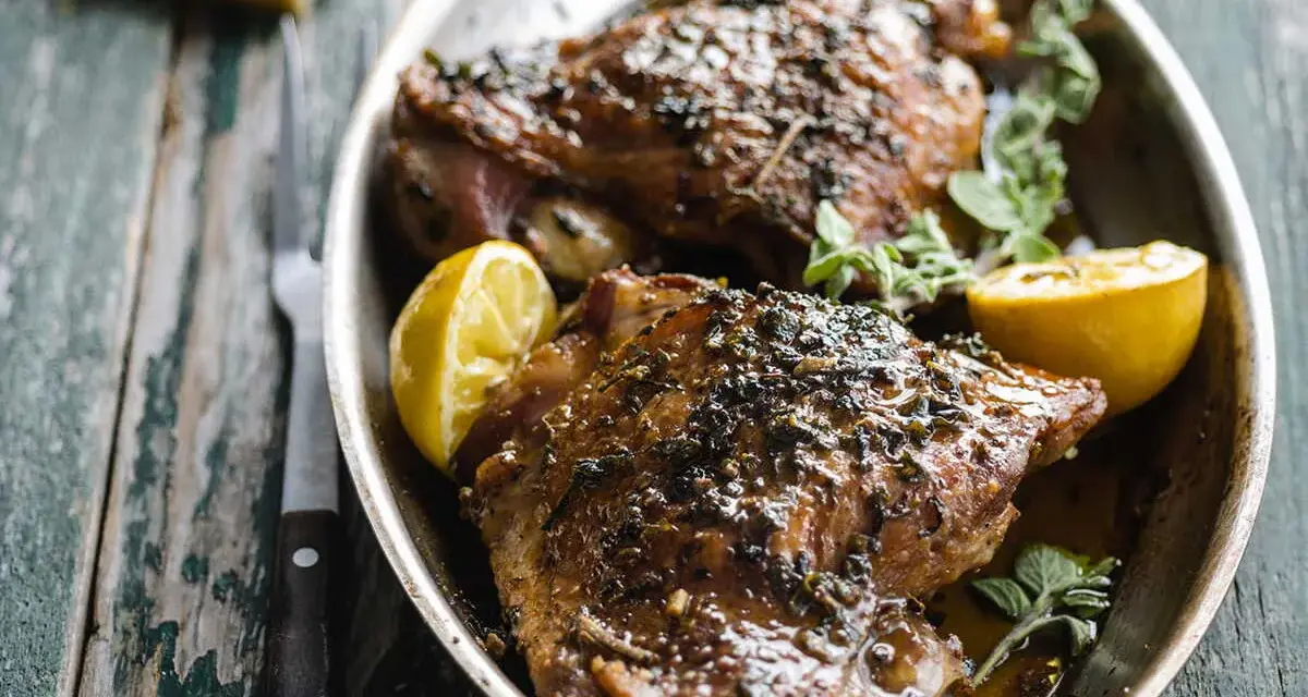 Deux belles cuisses de dinde au four, dorées et savoureuses, garnies de citron et d'herbes fraîches. Un délice !