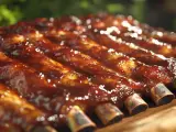 Des travers de porc généreusement nappés d'une sauce barbecue brillante, prêts à être dégustés.