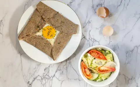 Galette de sarrasin garnie d'un œuf au plat, parfaite pour savoir que mettre dans une galette bretonne. Accompagnée d'une salade fraîche.