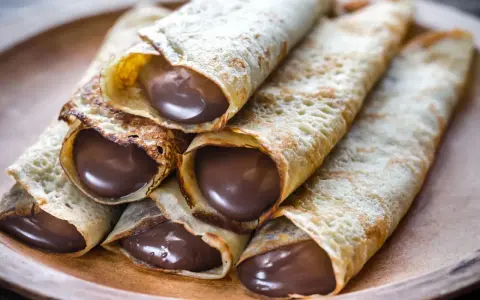 Crêpes roulées généreusement garnies de chocolat fondant. Une idée garniture crêpe sucrée irrésistible pour un goûter gourmand.