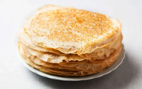 Pile de 10 crêpes sucrées dorées, prêtes à être garnies. Une recette simple pour un plaisir gourmand.