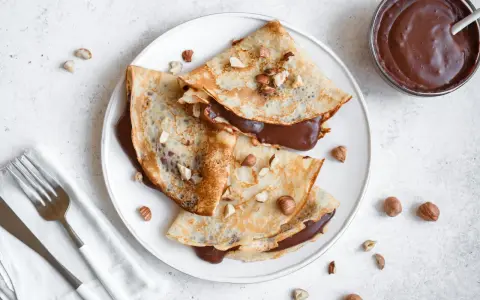 Crêpes garnies de nutella liquide pour crêpe, parsemées de noisettes concassées. Un délice gourmand !