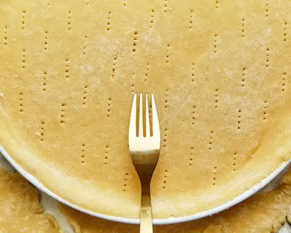 Une pâte brisée sans beurre, piquée à la fourchette, prête à être garnie.