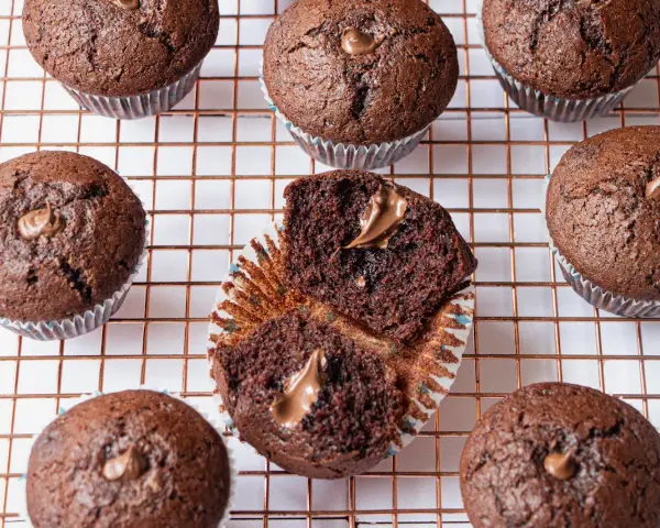 Plusieurs muffins au chocolat, dont un ouvert révélant une généreuse garniture de nutella.