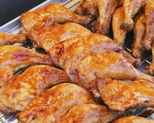 Une belle rangée de pilons de poulet rôtis, brillants d'une sauce caramélisée, prêts à être dégustés.