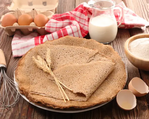 Délicieuses crêpes de pâte sarrasin, accompagnées d'œufs, de lait et de farine. Un délice rustique prêt à être dégusté.