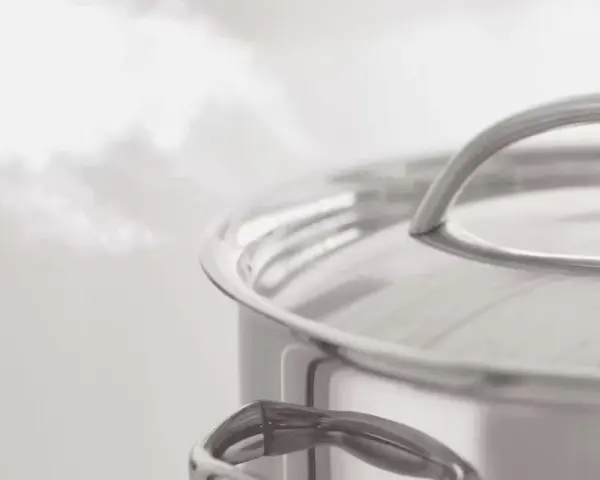 Vapeur s'échappant d'une casserole en inox. Le temps de cuisson du potimarron à l'eau approche de la fin.