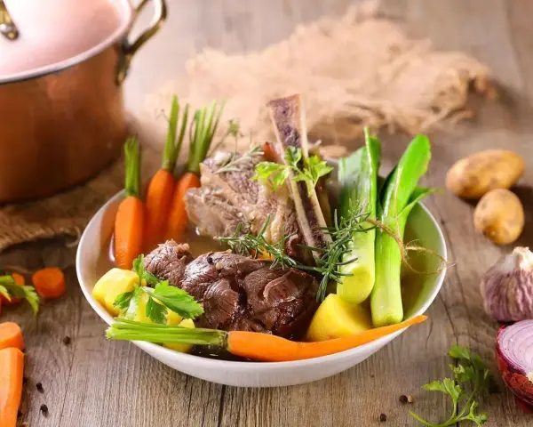 Un plat de pot-au-feu réconfortant avec du bœuf, des carottes, des poireaux et des pommes de terre, prêt à être dégusté.