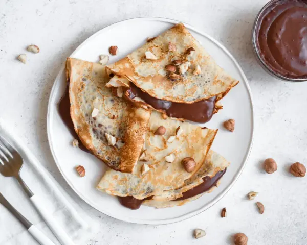 Crêpes garnies de nutella liquide pour crêpe, parsemées de noisettes concassées. Un délice gourmand !